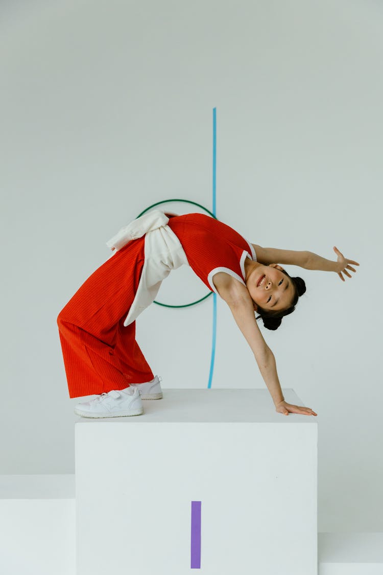 A Girl Standing On Winner Podium While Flexing Her Body