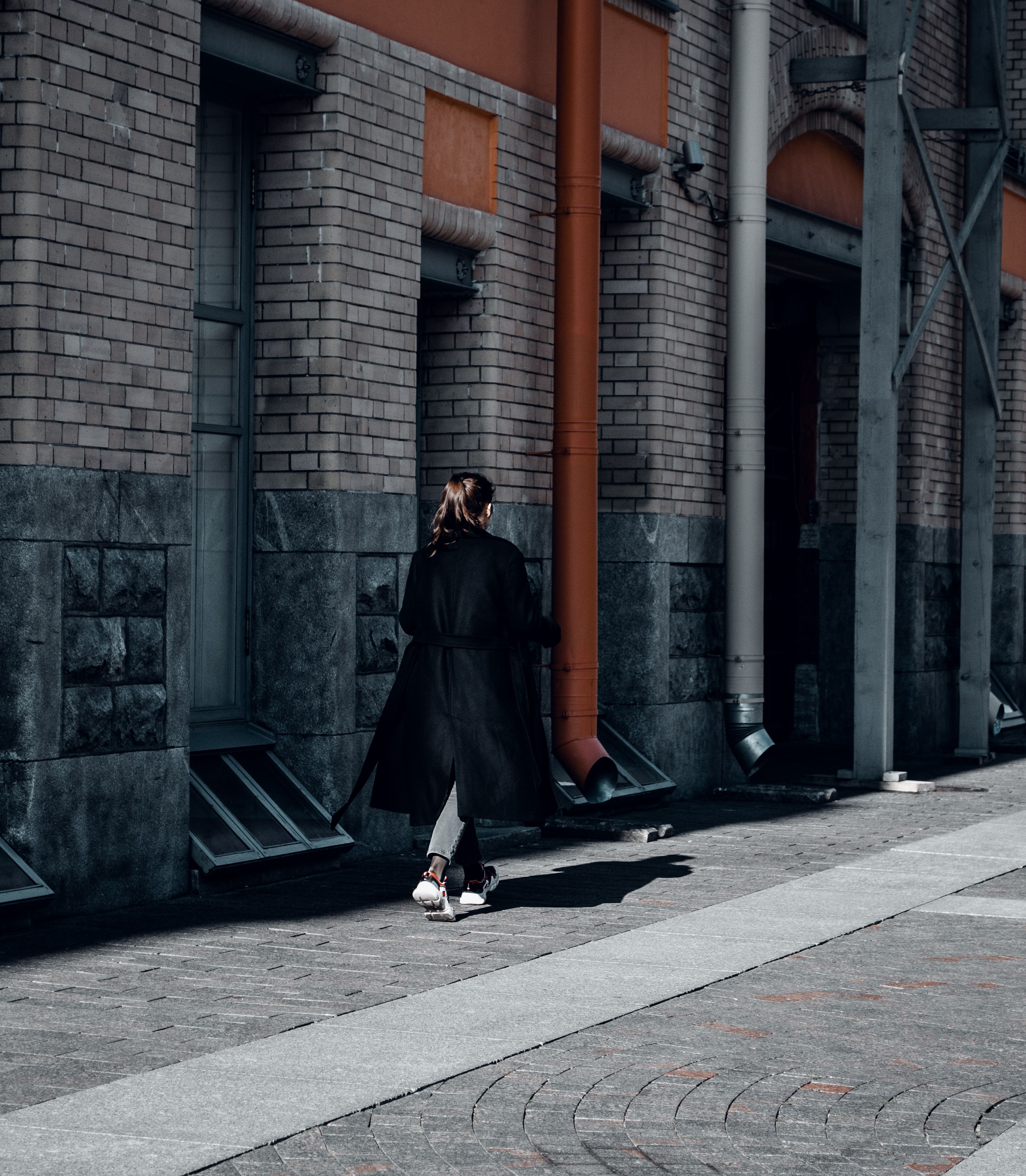 Woman in Black Coat Walking on Sidewalk · Free Stock Photo