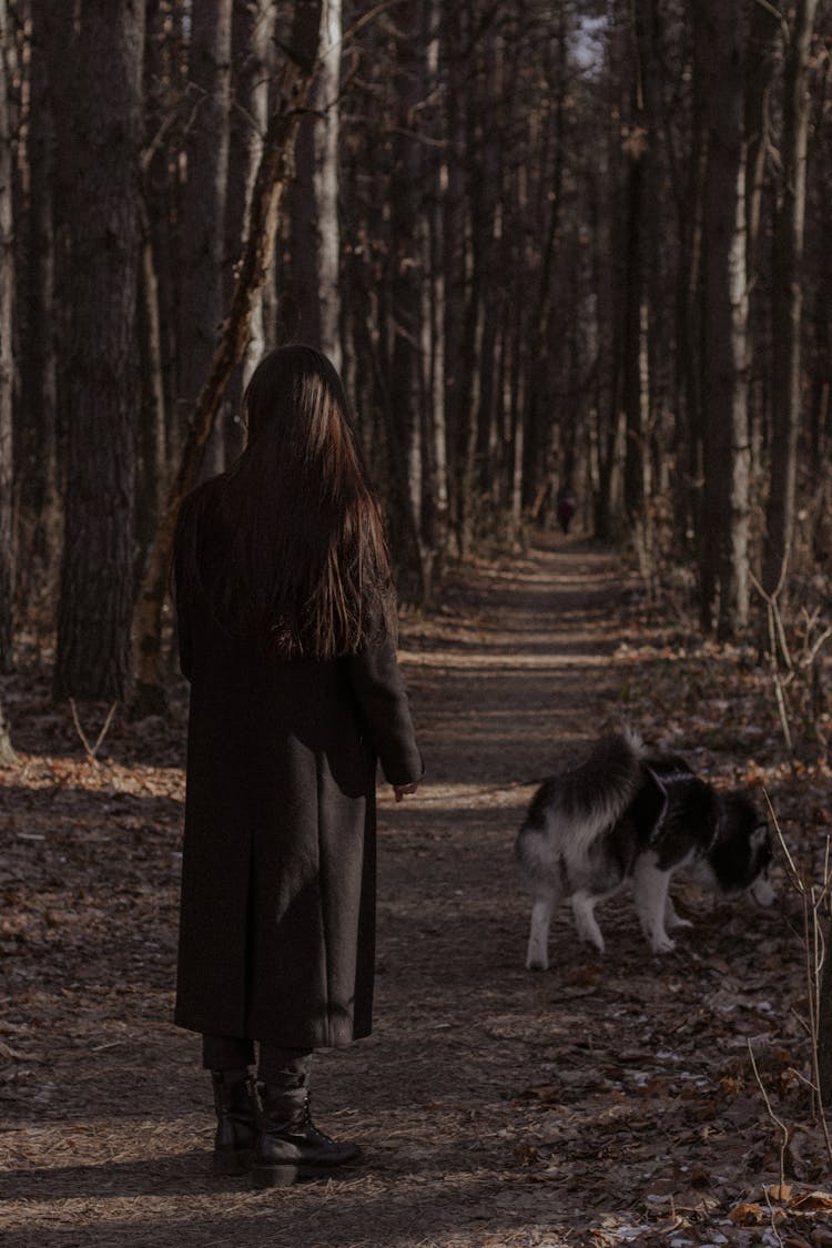 Woman In Black Coat Walking With Her Dog