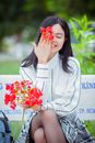Woman in White Button Up Shirt Holding Red Flower