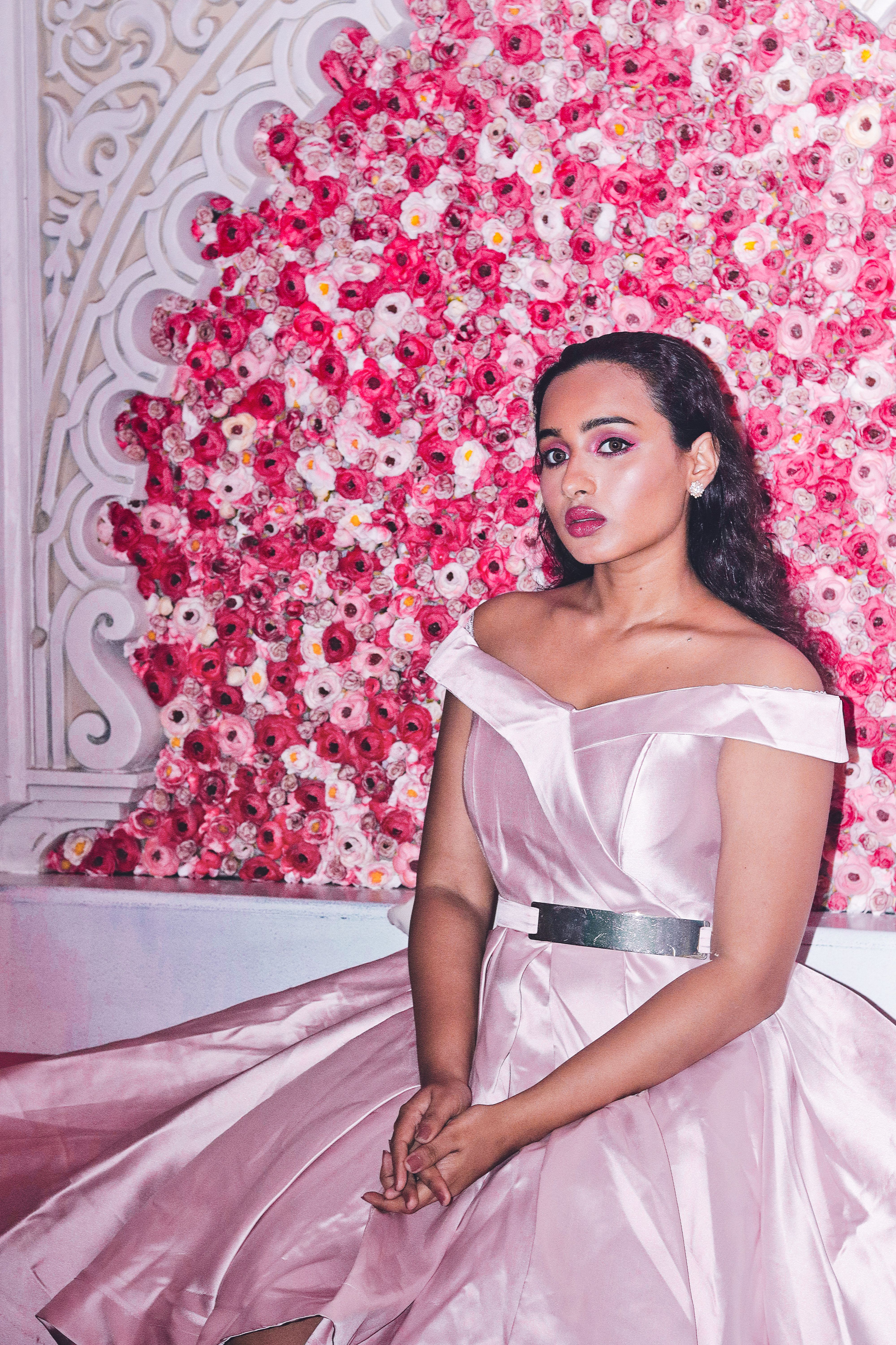 Woman in a Pink Dress Sitting Near Pink Flowers · Free Stock Photo