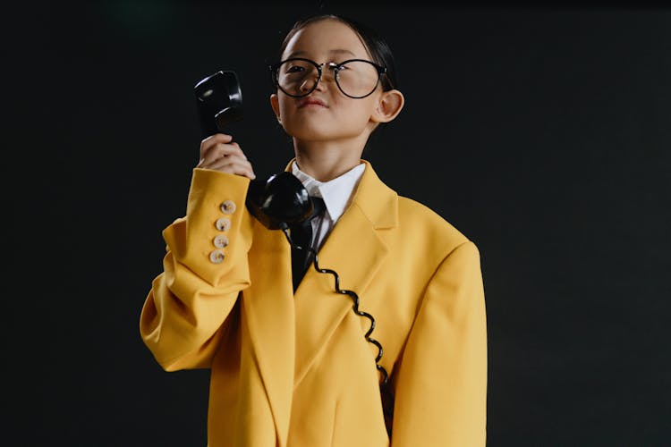 Asian Girl In Yellow Suit Holding Phone