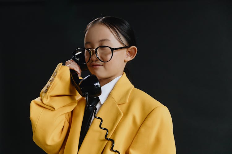 Profile View Of Asian Girl In Yellow Suit Holding Phone