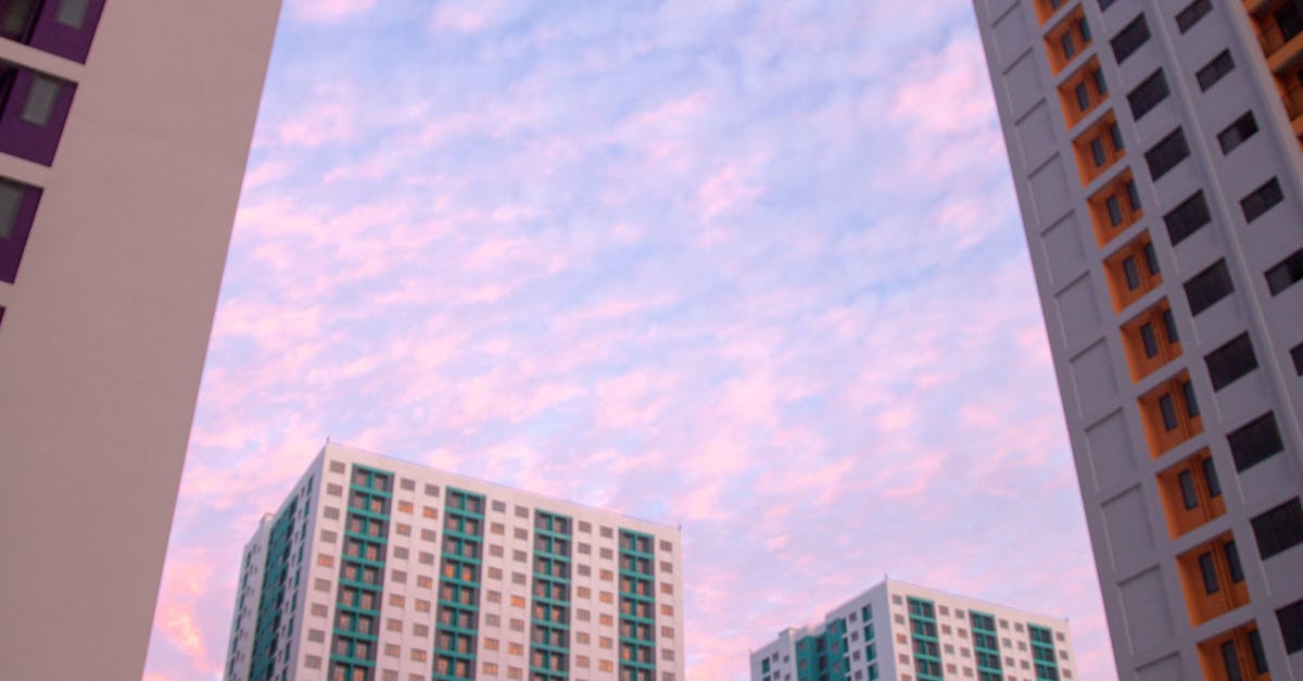 Photo by Asad Photo Maldives High-rise apartment buildings with a vibrant sunset sky creating a modern architectural cityscape.