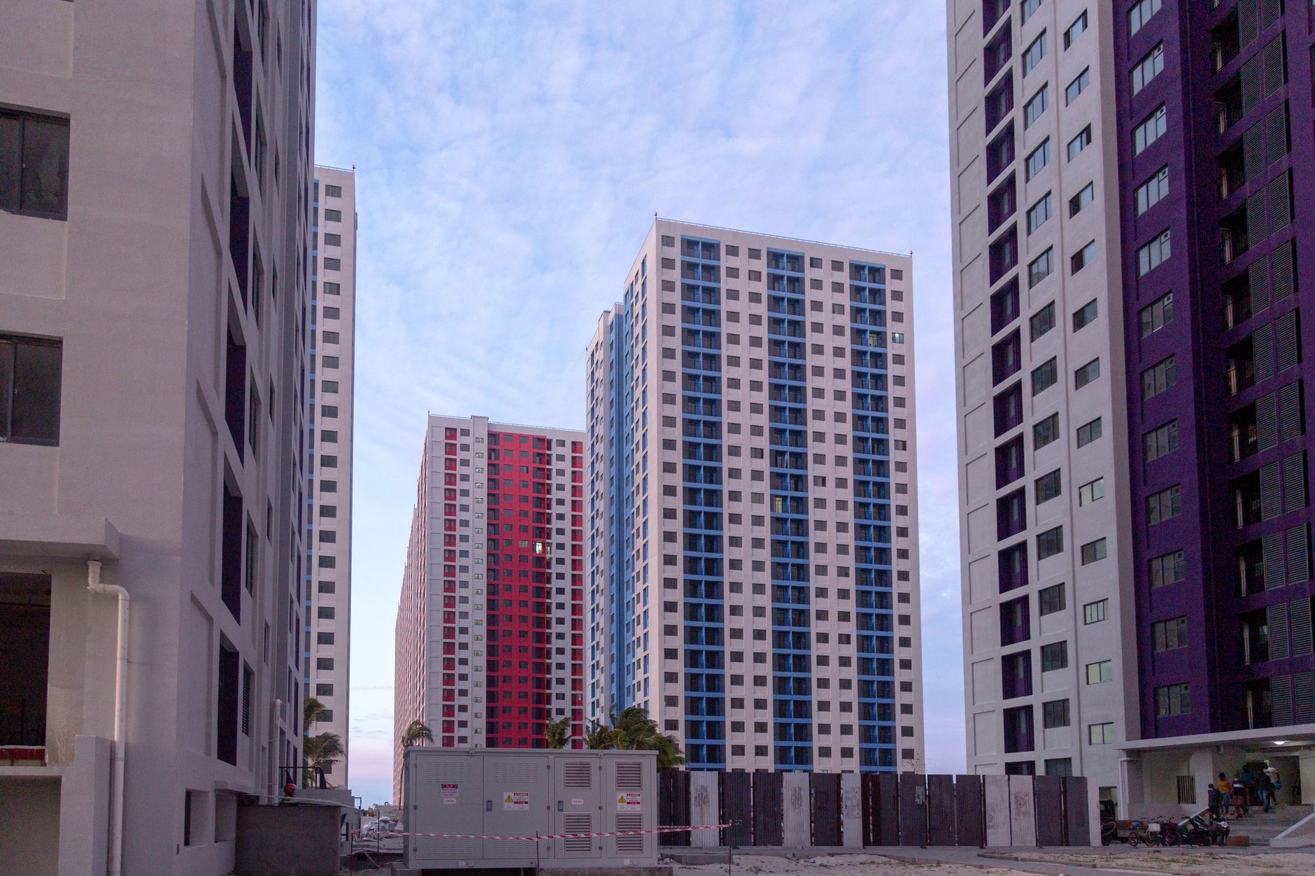 View of modern skyscraper apartment buildings during twilight with a serene sky.