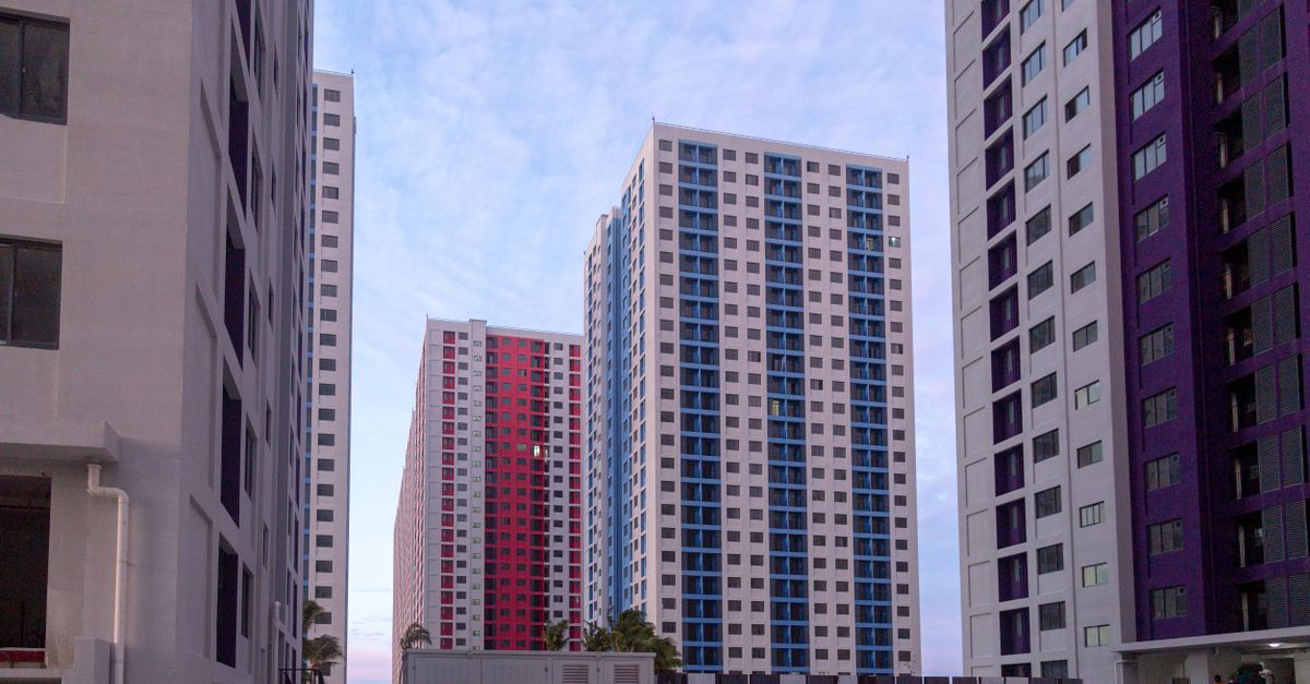 View of modern skyscraper apartment buildings during twilight with a serene sky.