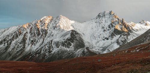 kar yağışlı, karla kaplı, kayalık Dağ içeren Ücretsiz stok fotoğraf