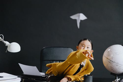 Asian girl throwing plane made from paper