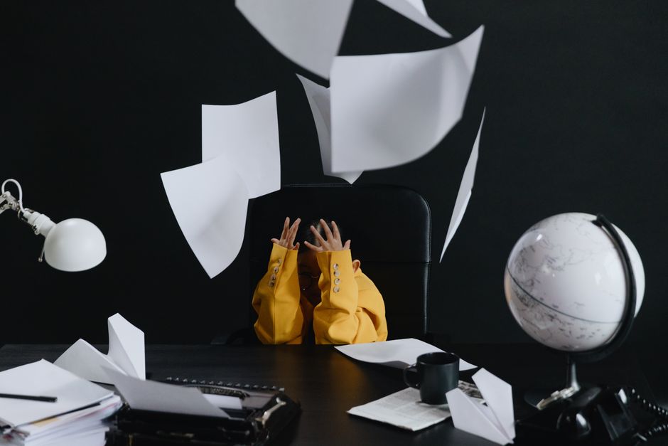 Why Debt Snowball vs Debt Avalanche Debate Misses the Point A child in a yellow suit throws papers in an office setting with a globe and typewriter.