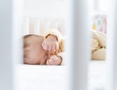 Small baby laying down on bed