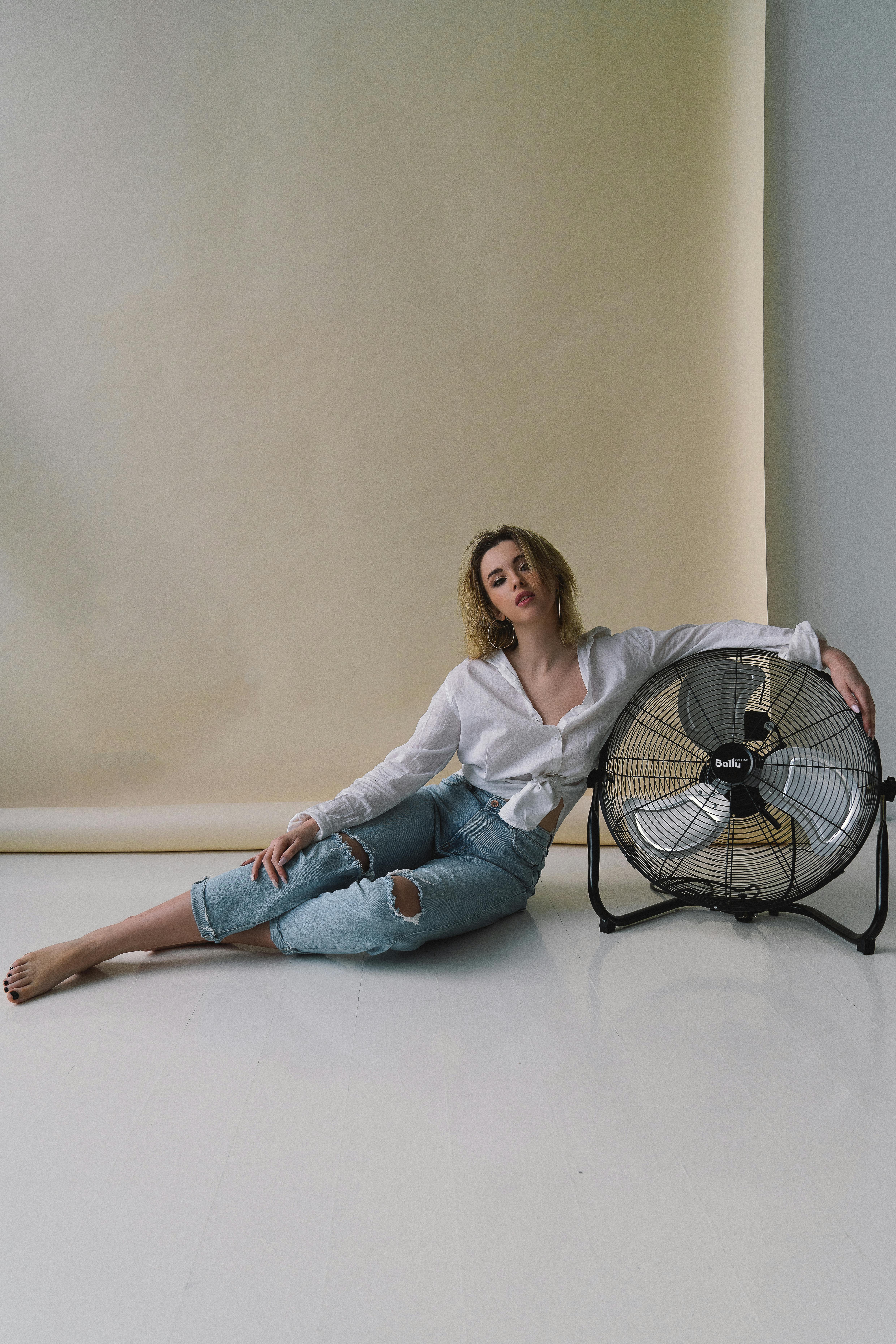 一位宁静的模特在工作室背景下与一位工业迷随意合影，拥抱现代时尚美学