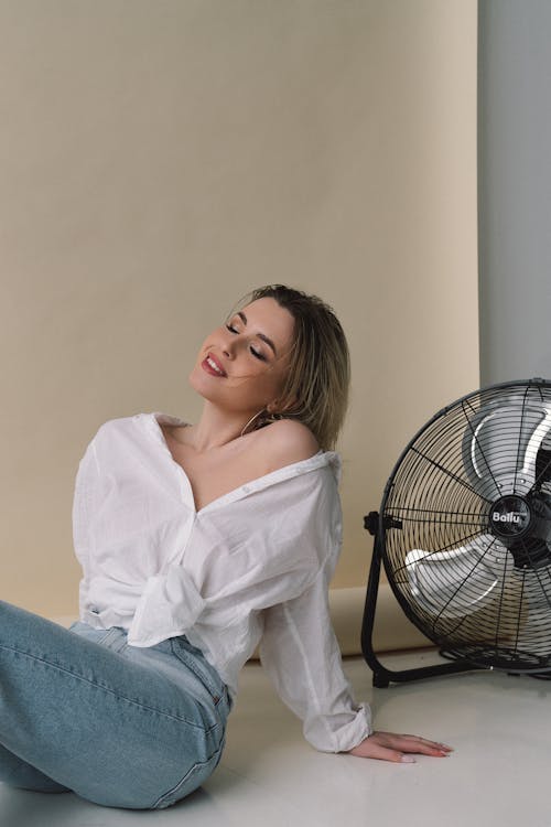 Studio shot of sitting woman with fan