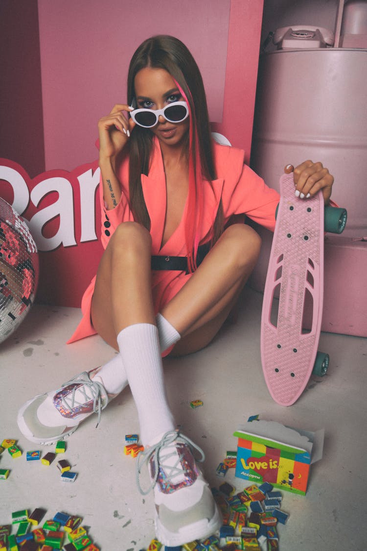 A Woman Wearing Sunglasses Holding Pennyboard