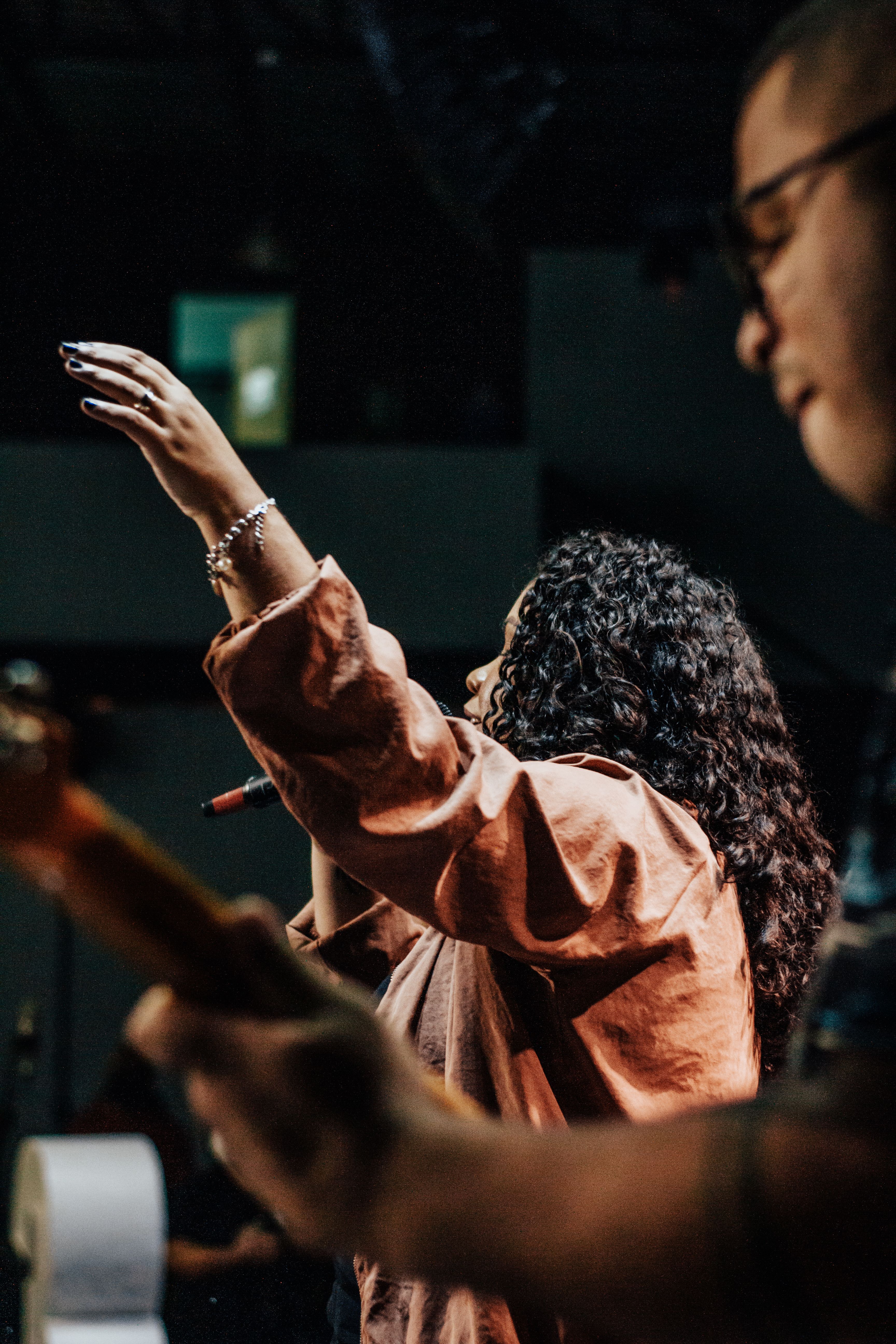 A singer and guitarist mid-song under warm stage light