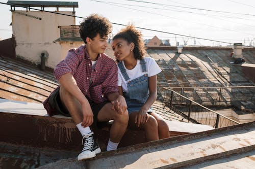 Free Teenage couple in love sitting on rooftop Stock Photo