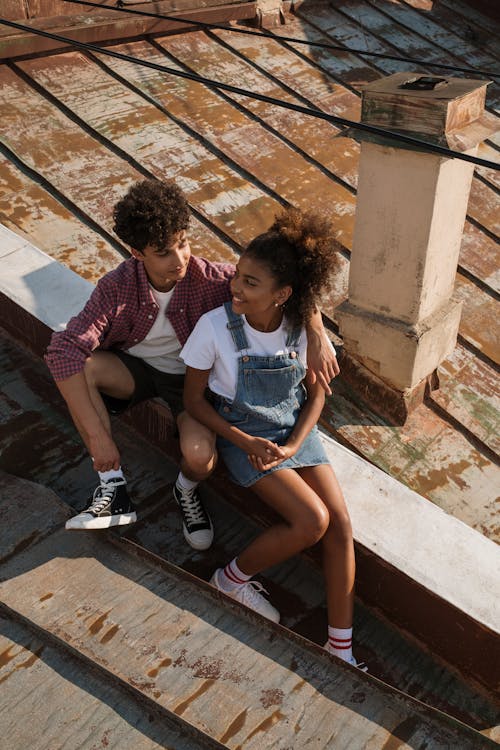 Teenage couple sitting on rooftop