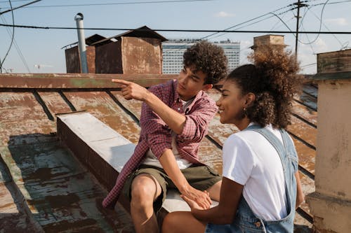 Free Teenage couple looking at view from rooftop Stock Photo