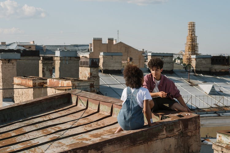 Teenage Couple Talking On Rooftop