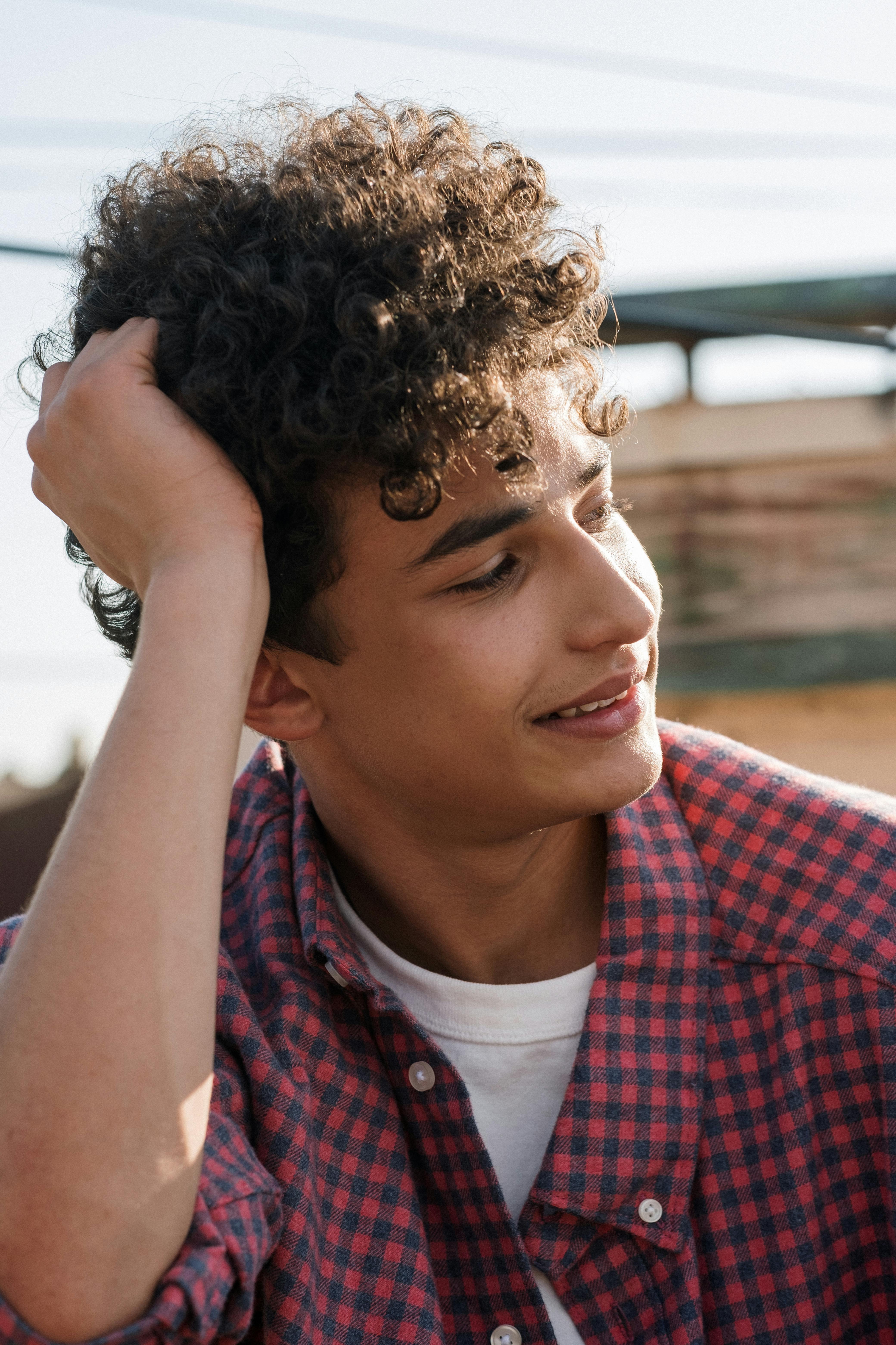 Portrait of teenage boy with curly hair · Free Stock Photo