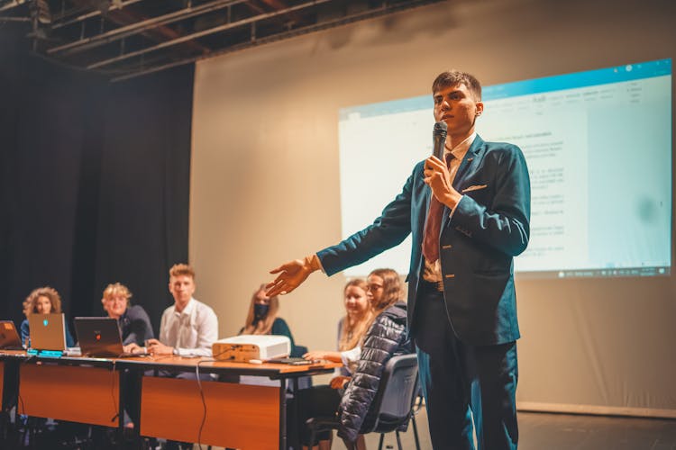 A Young Man Speaking On The Microphone