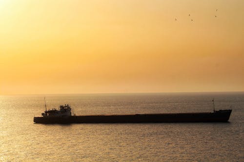 Free Silhouette of Ship on Sea during Sunset Stock Photo