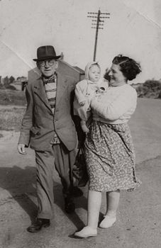 A classic black and white photo of a family walk, showcasing timeless vintage fashion.