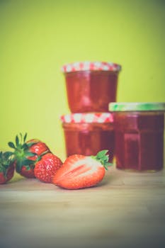 Strawberry Near Red Jar on Wooden Surface