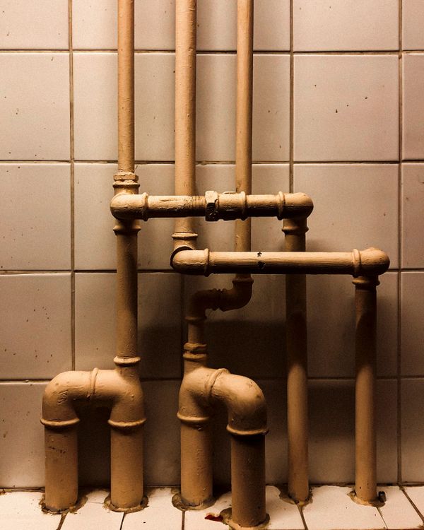 Plumbing pipework detail against tiling