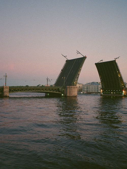 Free Scenic view of a drawbridge opening over a river during sunset in a cityscape. Stock Photo
