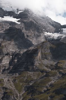 Scenic aerial view of the rugged Swiss Alps showcasing snow-capped peaks and rocky terrain.