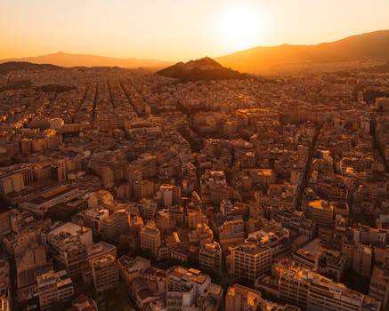 Captivating aerial view of Athens with a warm sunset over the cityscape.