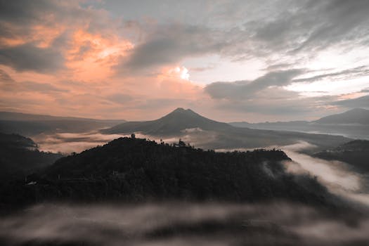 A breathtaking aerial shot of Bali's misty mountains during sunrise. Perfect for nature and travel enthusiasts.