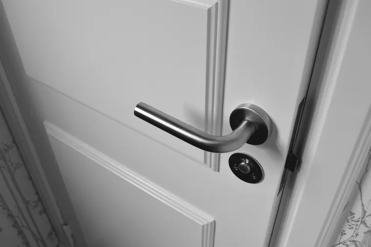 Porte intérieure blanche avec poignée et petit bouton de condamnation, exemple de serrure de porte intérieure