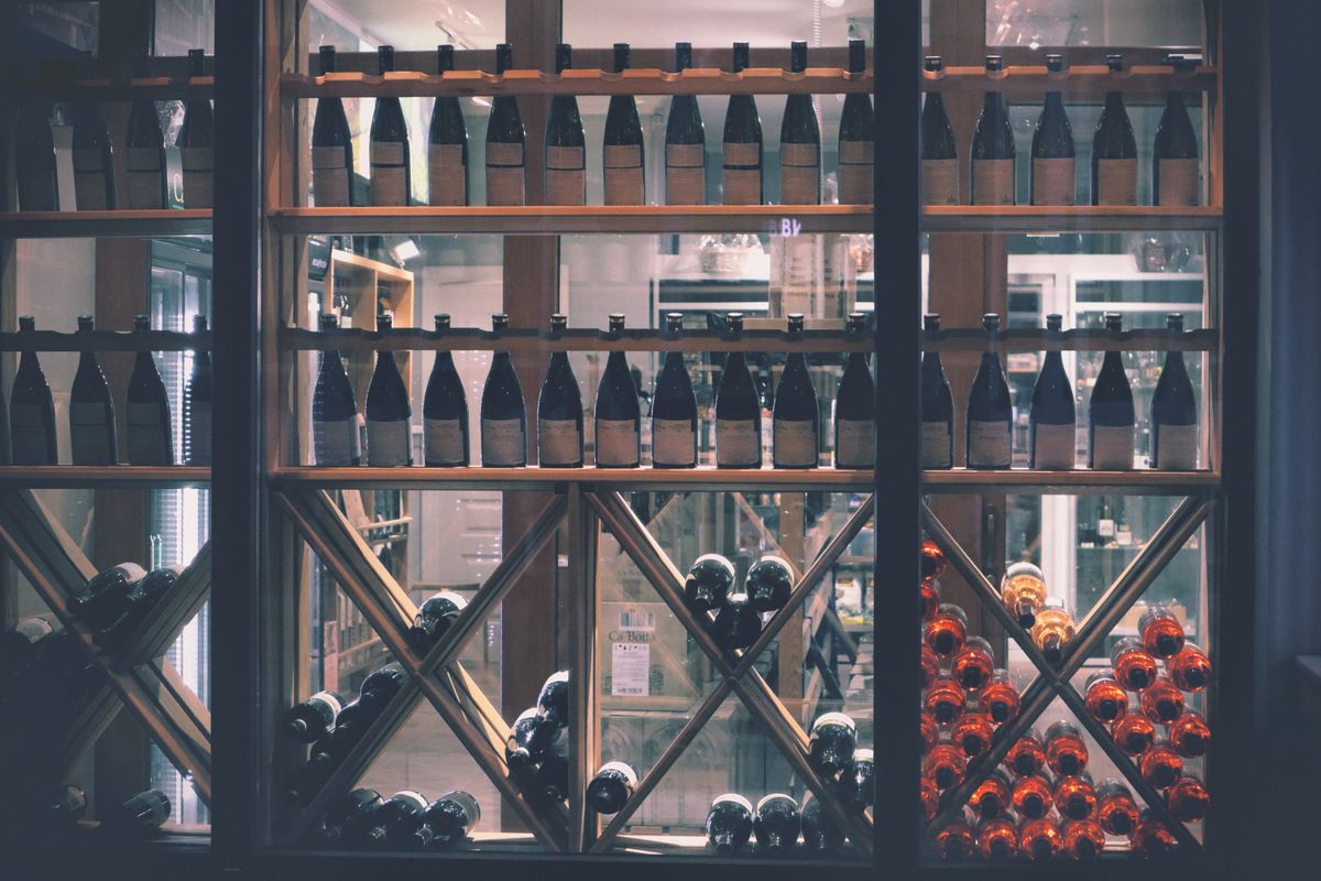 Sticle de vin pe rafturi într-o cramă