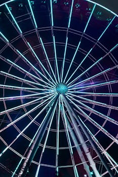 Illuminated Ferris wheel towering against a night sky, showcasing vibrant lights in Puebla, Mexico.