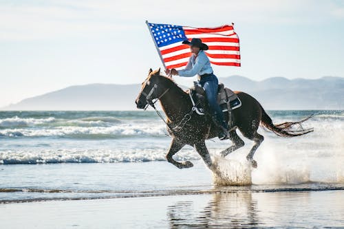 Woman Holding a Flag While Riding a Horse