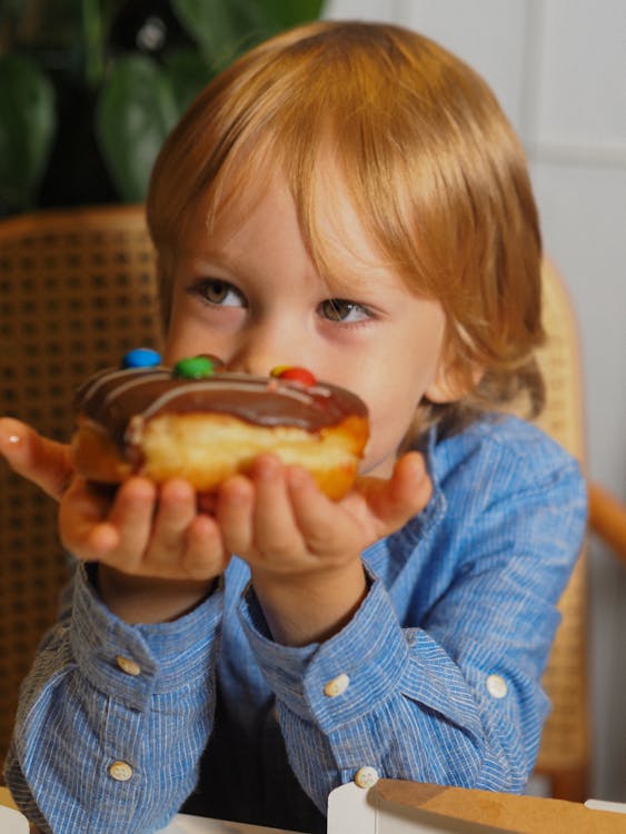 A Boy Holding a Donut