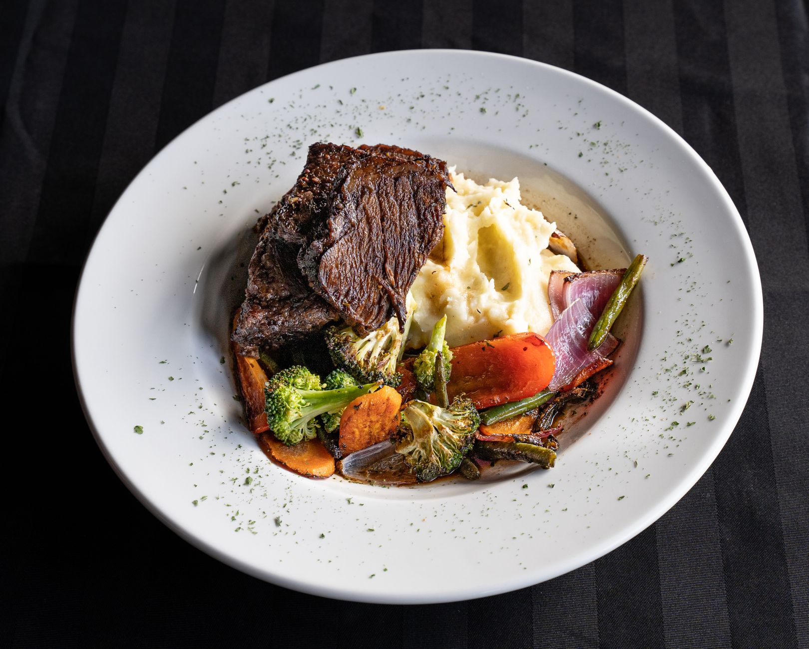 Plated roast beef with roasted potatoes, carrots, and onions