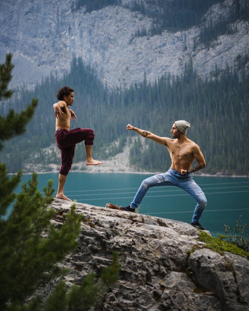 Men Doing Martial Arts on Top of a Rock