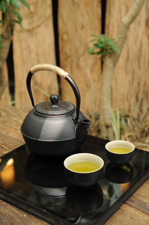 Photo of a Black Teapot Beside Cups