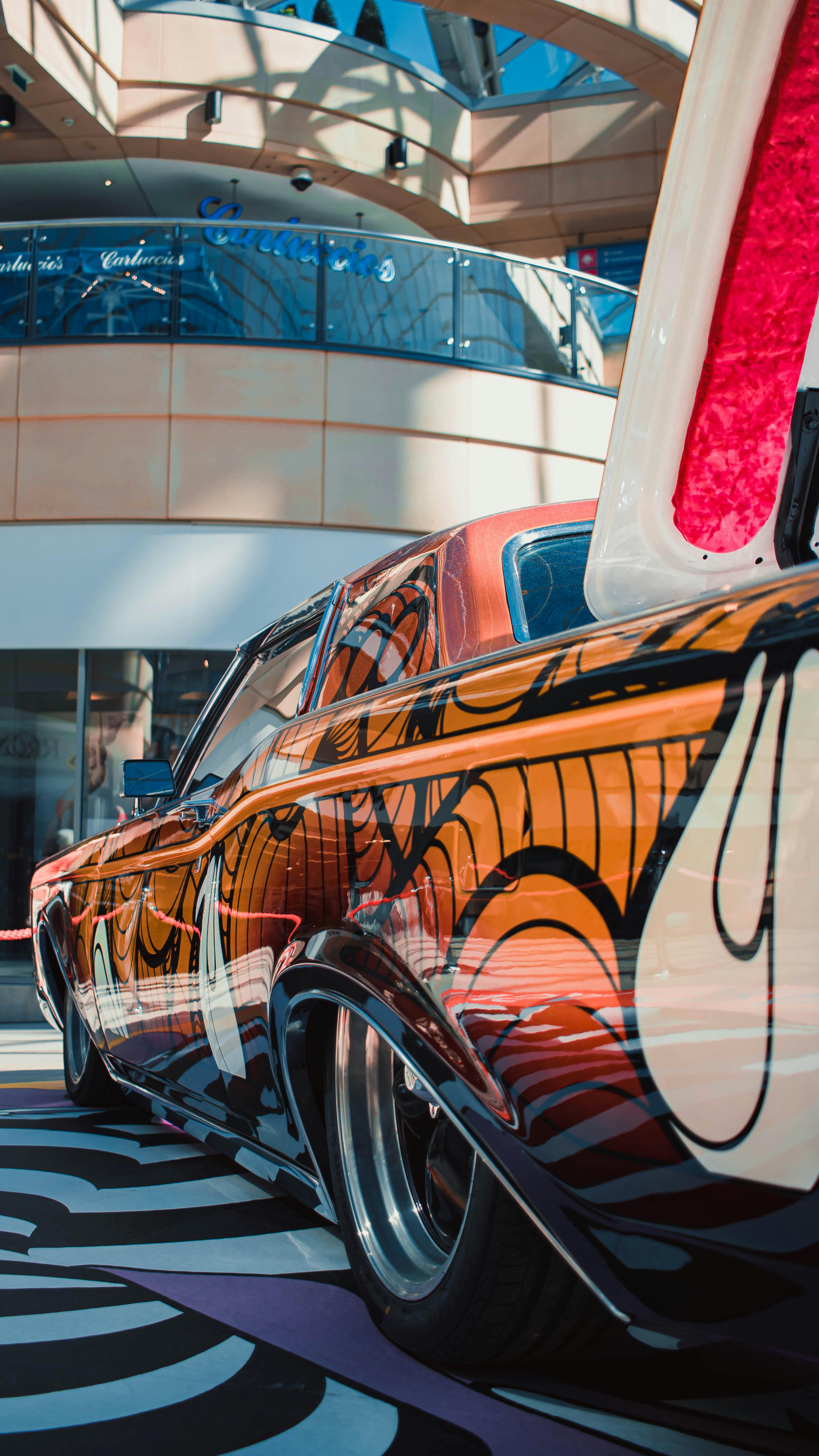 Free Vibrant custom car with artistic paint design parked indoors at a Leeds shopping center. Stock Photo