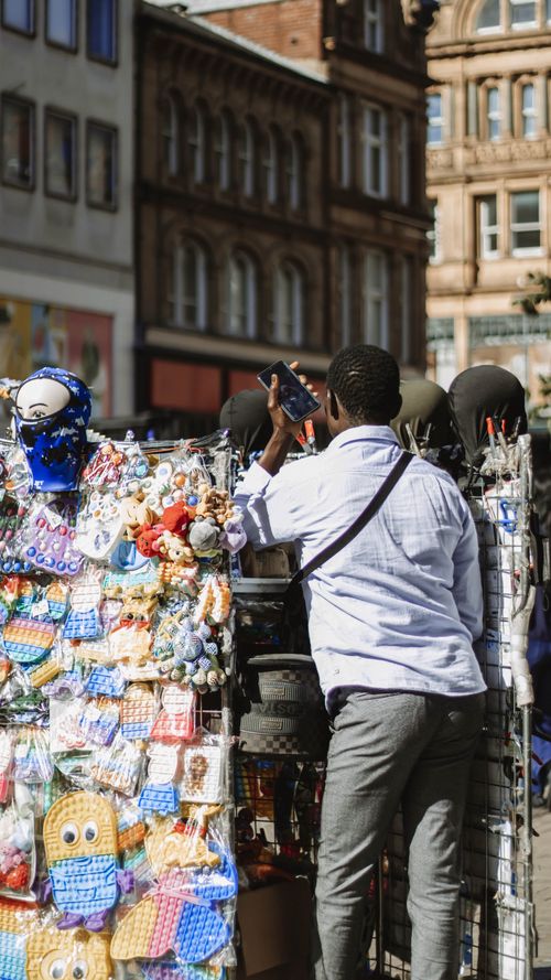 Free Man capturing a vibrant street vendor scene in Leeds. Urban life and culture. Stock Photo