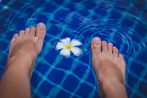 Free Person's Feet on Swimming Pool Stock Photo