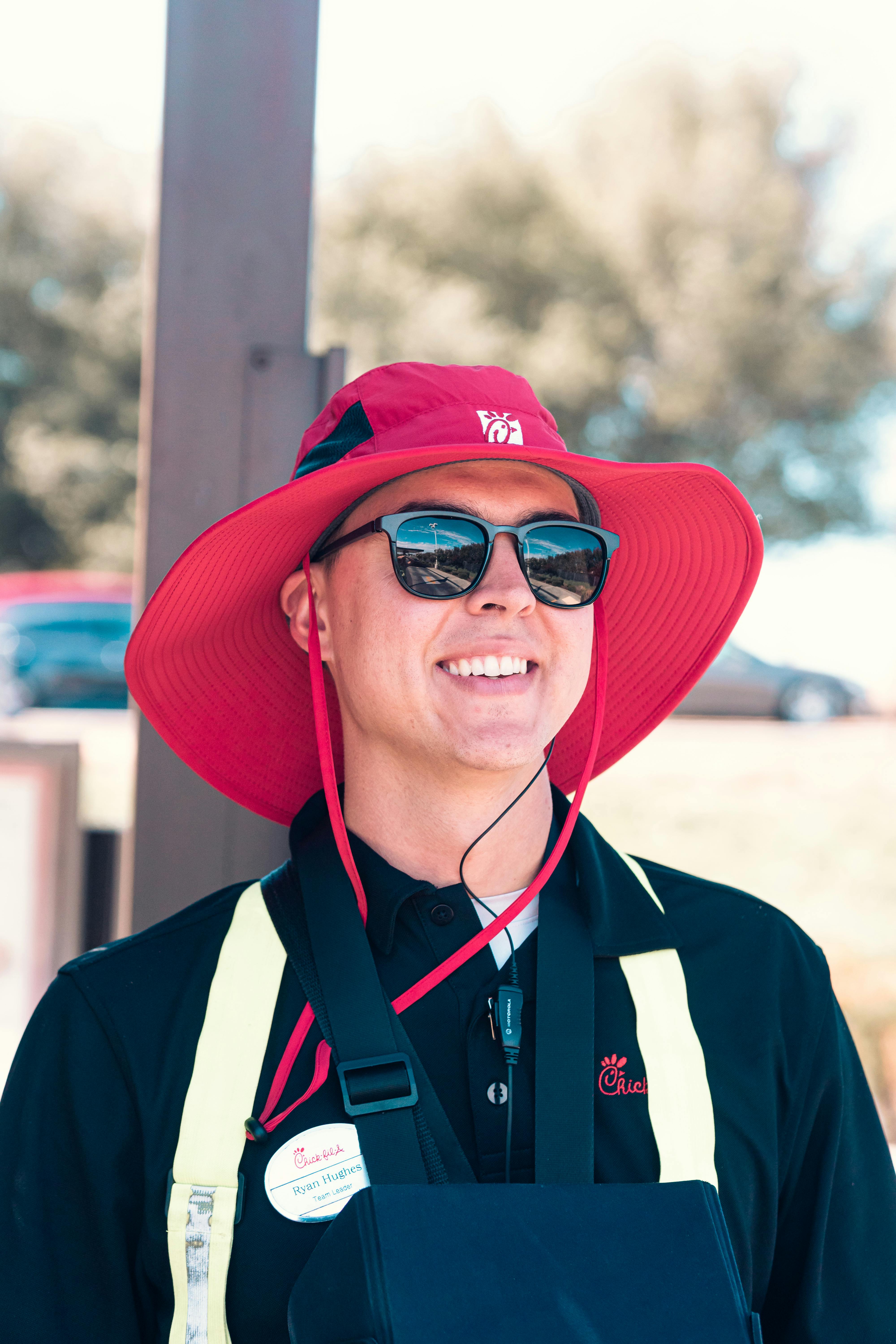 man wearing red hat and black polo shirt