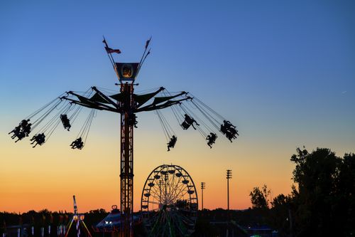 Free Amusement park ride and Ferris wheel silhouetted against a vibrant sunset sky in Boise, Idaho. Stock Photo
