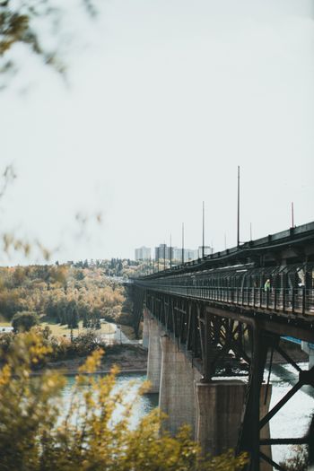 A steel bridge spanning a river with a city skyline behind it — photo by Jonathan Cooper on Pexels