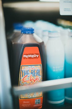 Close-up of chai and bottled water in refrigerator, showcasing product labels.