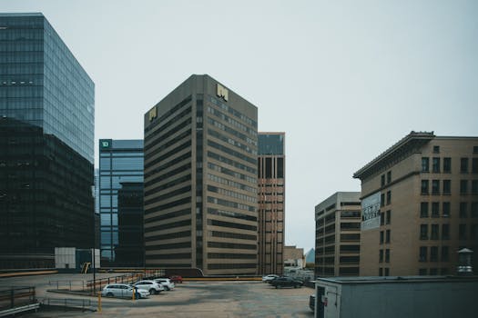 Contemporary city skyline featuring high-rise office buildings and a parking lot.