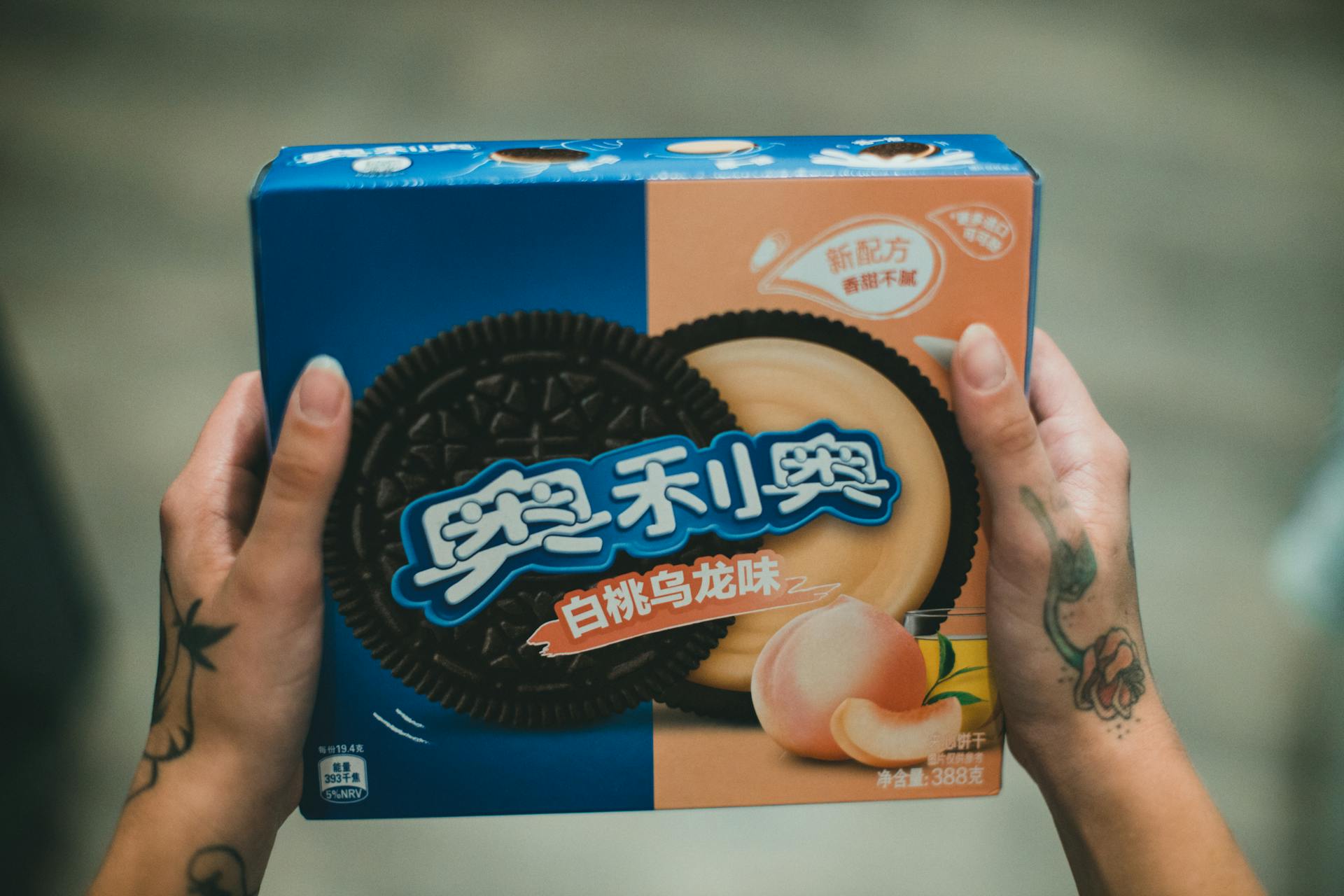 Woman Holding a Box of Peach Oreo Cookies