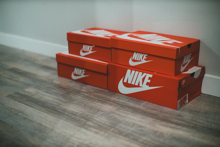 Nike Shoe Boxes In Various Sizes On Wooden Floor